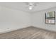 Bright bedroom features wood-look flooring, a ceiling fan, and window at 5390 Nw 12Th Pl, Ocala, FL 34482