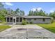 Rear exterior of single-story home featuring enclosed sunroom and concrete patio at 5390 Nw 12Th Pl, Ocala, FL 34482
