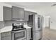 Modern kitchen featuring stainless steel appliances, gray subway tile backsplash, and quartz countertops at 5390 Nw 12Th Pl, Ocala, FL 34482