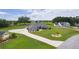 Aerial view of a home with lush landscaping, mature trees, and long driveway at 5429 County Road 125, Wildwood, FL 34785