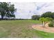 Beautiful grassy backyard with black fencing and landscaping with mature trees at 5429 County Road 125, Wildwood, FL 34785