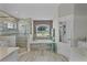 Luxurious bathroom featuring a soaking tub, glass-enclosed shower, and neutral tile work at 5429 County Road 125, Wildwood, FL 34785