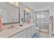 Bright bathroom features double sinks, elegant mirrors, and a tiled shower at 5429 County Road 125, Wildwood, FL 34785