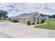 Charming home with multiple garages, a lush front lawn and manicured landscaping at 5429 County Road 125, Wildwood, FL 34785