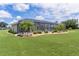 The beautifully landscaped backyard features a screened in pool and palm trees at 5429 County Road 125, Wildwood, FL 34785