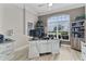 Bright home office featuring a distressed white desk, large window, and built-in shelving for ample storage space at 5429 County Road 125, Wildwood, FL 34785