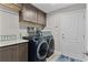 Modern laundry room with front-load washer and dryer, ample cabinet space, and countertop at 5429 County Road 125, Wildwood, FL 34785