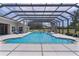 Enclosed swimming pool with a slide, blue water, plenty of lounging area and an expansive yard beyond at 5429 County Road 125, Wildwood, FL 34785