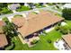 Aerial view of a home with a lush green lawn, patio, and manicured landscaping at 5512 Rosewall Cir, Leesburg, FL 34748