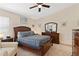 Comfortable bedroom with ceiling fan, cozy carpet, and classic wooden furniture at 5512 Rosewall Cir, Leesburg, FL 34748