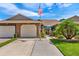 Charming home featuring an American flag, manicured landscaping and attached two car garage at 5512 Rosewall Cir, Leesburg, FL 34748