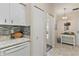 Cozy kitchen featuring modern backsplash, white cabinets, and sleek countertops at 5512 Rosewall Cir, Leesburg, FL 34748