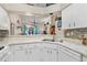 Well-lit kitchen with white cabinets and modern appliances, offering a view of the adjacent living area at 5512 Rosewall Cir, Leesburg, FL 34748