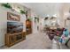 Spacious living room with a TV, bookshelf, dining area, and partial view of the open kitchen at 5512 Rosewall Cir, Leesburg, FL 34748
