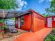 Red building with patio cover, hot tub, chairs, fire pit and red concrete pad at 564 Lancaster Ave, Orange City, FL 32763