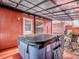 Relaxing backyard with a covered hot tub, red walls, and a gravel-covered seating area at 564 Lancaster Ave, Orange City, FL 32763