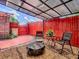 Landscaped backyard with gravel, fire pit, red fence, and a covered dining area at 564 Lancaster Ave, Orange City, FL 32763