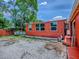 Backyard of a red building, with a raised garden bed and steps up to a red porch at 564 Lancaster Ave, Orange City, FL 32763
