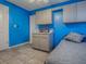 A bedroom featuring bright blue walls, tile floors, built-in cabinets, and a cozy bed at 564 Lancaster Ave, Orange City, FL 32763