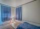 Bedroom featuring blue curtains, wood-look floors and modern lamp at 564 Lancaster Ave, Orange City, FL 32763