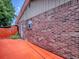 Exterior brick wall with a view of a door and red painted ground at 564 Lancaster Ave, Orange City, FL 32763