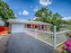 Inviting brick home featuring an orange porch, white picket fence, and a well-maintained lawn at 564 Lancaster Ave, Orange City, FL 32763