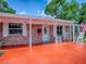 Welcoming front porch features rocking chairs, a brick facade, white trim, and an orange painted porch at 564 Lancaster Ave, Orange City, FL 32763