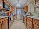 Galley style kitchen with stainless appliances, brick veneer, and tile flooring at 564 Lancaster Ave, Orange City, FL 32763