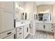 Well-lit bathroom with dual vanities, marble countertops, and modern gray wood-look flooring at 5746 Botner Dr, The Villages, FL 32163