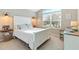 Bedroom with a white bed, woven accents, and a large window bringing in natural light at 5746 Botner Dr, The Villages, FL 32163