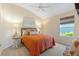 Comfortable bedroom with neutral carpet, ceiling fan, large window, and a decorative art piece at 5746 Botner Dr, The Villages, FL 32163