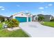 Front exterior of home boasts a 3-car garage, lush green lawn, and manicured landscaping at 5746 Botner Dr, The Villages, FL 32163