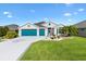 Charming single-story home with a three-car garage, well-manicured lawn, and beautiful landscaping at 5746 Botner Dr, The Villages, FL 32163