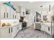 Modern white kitchen featuring stainless steel appliances, quartz countertops, and stylish decor at 5746 Botner Dr, The Villages, FL 32163
