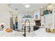 Bright kitchen with white cabinetry, stainless steel appliances, unique lighting and lovely quartz countertops at 5746 Botner Dr, The Villages, FL 32163