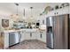 Open kitchen design with stainless steel appliances, white cabinetry, and views of the dining and living areas at 5746 Botner Dr, The Villages, FL 32163