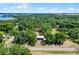 Aerial view of a spacious lot nestled among mature trees with a blue shed and lake in the distance at 5825 Lake Emma Ct, Groveland, FL 34736