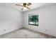 This bedroom has a ceiling fan and a view to the outdoors through a large window at 5825 Lake Emma Ct, Groveland, FL 34736