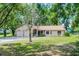 Charming single-story home featuring a three car garage, screened porch, and a well-manicured front lawn at 5825 Lake Emma Ct, Groveland, FL 34736