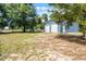Exterior shot of a spacious blue garage with two white doors, surrounded by lush greenery and a well-maintained lawn at 5825 Lake Emma Ct, Groveland, FL 34736