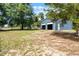 Exterior shot of a spacious blue garage with an open door, surrounded by lush greenery and a well-maintained lawn at 5825 Lake Emma Ct, Groveland, FL 34736