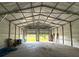 Interior view of garage featuring a high ceiling and an open garage door that reveals backyard trees and greenery at 5825 Lake Emma Ct, Groveland, FL 34736