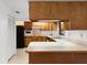 Efficient kitchen with wood cabinetry, a white countertop, and standard appliances at 5825 Lake Emma Ct, Groveland, FL 34736
