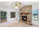 Cozy living room featuring a stone fireplace, vaulted ceilings, a ceiling fan, and natural light at 5825 Lake Emma Ct, Groveland, FL 34736