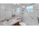Bright bathroom with glass shower doors, white tiling, and accessible handrails at 6556 Piccadilly Ln, Orlando, FL 32835