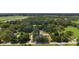 Aerial view shows the home's property lines and wooded surroundings, creating a private oasis at 672 E Belt Ave, Bushnell, FL 33513