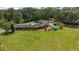 Aerial view of a ranch style home with a large yard with a pool and tropical vegetation in a rural setting at 672 E Belt Ave, Bushnell, FL 33513