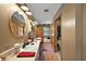 Well-lit bathroom featuring dual sinks, a long vanity, wood floors, and a convenient toilet room at 672 E Belt Ave, Bushnell, FL 33513