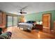 Bedroom with hardwood floors, sliding doors, ceiling fan, and ample natural light at 672 E Belt Ave, Bushnell, FL 33513