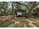 Outdoor carport adjacent to house, shaded by mature trees, ideal for parking an RV at 672 E Belt Ave, Bushnell, FL 33513